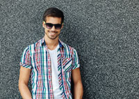 Przystojny mężczyzna w kolorowej koszuli i okularach przeciwsłonecznych