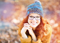 Uśmiechnięta dziewczyna w okularach i zimowej czapce