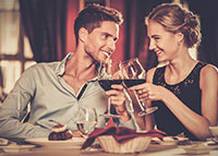 Para stukająca się kieliszkami z winem w trakcie romantycznej kolacji