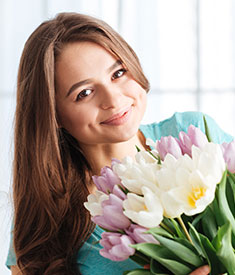 Uśmiechnięta kobieta z bukietem kwiatów
