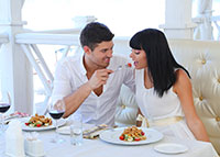 Para w trakcie kolacji, mężczyzna karmi kobietę