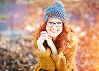 Młoda dziewczyna o pięknym uśmiechu w niebieskiej czapce