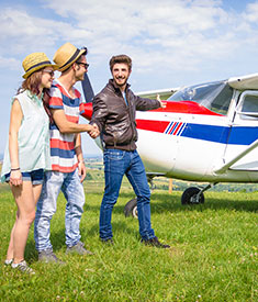 Młodzi ludzie witający się z pilotem tuż przed lotem samolotem