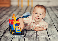 Mały chłopiec bawi się zabawkowym pojazdem