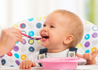 Uśmiechnięte niemowlę w trakcie karmienia