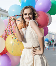 Uśmiechnięta, młoda kobieta z kolorowymi balonami