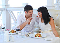 Mężczyzna karmiący kobietę w trakcie romantycznej kolacji
