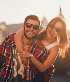 Para uśmiechniętych młodych ludzi w okularach przeciwsłonecznych