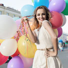 Uśmiechnięta obieta z kolorowymi balonami