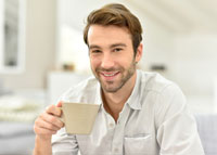 Uśmiechnięty mężczyzna pijący kawę